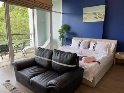 a bed and a leather couch in a room at veloche group 2 in Karon Beach