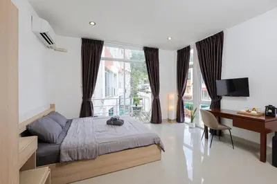 a bedroom with a bed and a desk and a desk at StayKa Suites in Karon Beach
