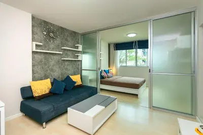 a living room with a blue couch and a bed at Tony DCondo in Kathu