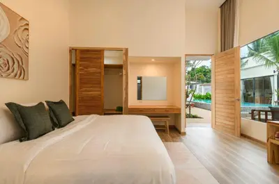 a bedroom with a large bed and a television at Dutch Villas Phuket in Koh Lone