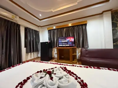 a bedroom with a bed and a tv in a room at Beach Comber in Patong Beach