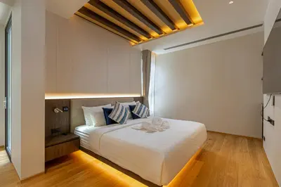 a bedroom with a bed with white sheets and blue pillows at Layana Residence in Layan Beach