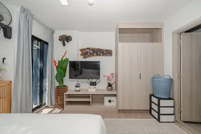 a room with a bed and a tv on a wall at C175 Stylish Condo with Pool View D Condo Phuket in Kathu