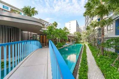 a swimming pool with a blue fence next to a building at C175 Stylish Condo with Pool View D Condo Phuket in Kathu
