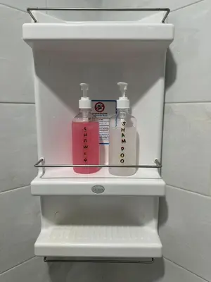 a white shelf with two soap bottles in a bathroom at Patong Tower in Patong Beach