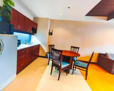 a kitchen with a table and chairs in a kitchen at Patong Tower in Patong Beach