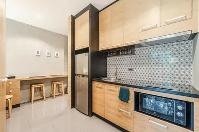 a kitchen with wooden cabinets and a stainless steel refrigerator at C179 Serene and Stylish Getaway in Kamala, Phuket in Kamala Beach