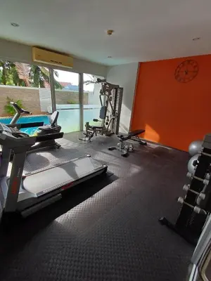 a gym with cardio equipment and a swimming pool at Chic Condominium in Karon Beach