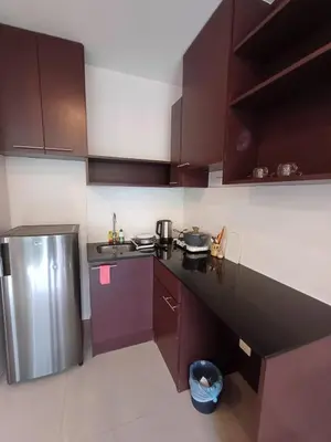 a kitchen with purple cabinets and a stainless steel refrigerator at Chic Condominium in Karon Beach