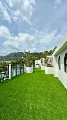 a large yard with green grass and a fence at Fantasea Kamala Beach 1 BR 313 in Kamala Beach
