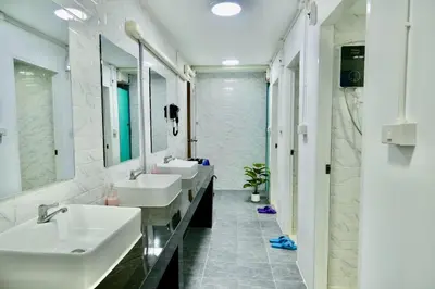 a bathroom with three sinks and two mirrors at The City Hostel in Phi Phi Don