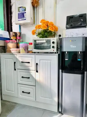a kitchen with a microwave and a refrigerator at The City Hostel in Phi Phi Don