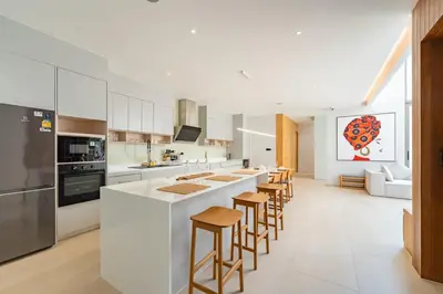 a kitchen with a large white island with bar stools at V183 Lux Pride Villas 3BR Private Pool Retreat in Bang Tao Beach
