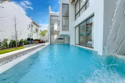 a swimming pool in a house with a waterfall at Designer 3BR Pool Villa in New Build LuxPride 4 L8 Residence in Bang Tao Beach
