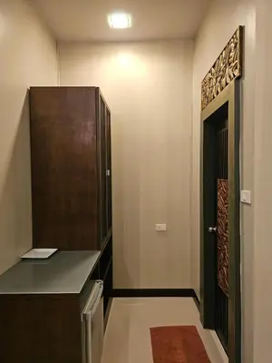 a dressing room with a wooden door and a black cabinet at The house on the hill in Ban Na Kok