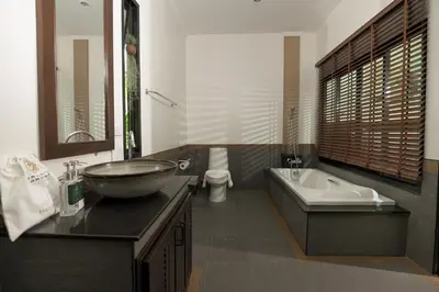 a bathroom with a bowl sink and a tub at Green Garden Villa Hotel in Nai Harn Beach