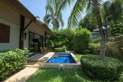 a swimming pool in the yard of a house at Green Garden Villa Hotel in Nai Harn Beach