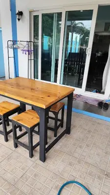 a wooden table with a bench and a table and chairs at Maison local avec terrasse et cuisine extérieure Proche Patong in Kathu