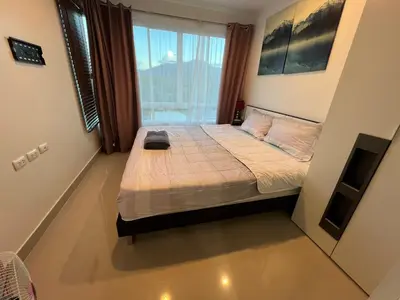 a small bedroom with a bed with a large window at Plus 1 Condo 202-67 in Kathu