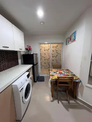 a small kitchen with a washing machine and a table at Plus 1 Condo 202-67 in Kathu