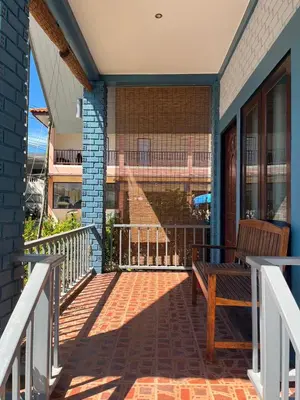 a porch with a bench on a house at J&B House in Nai Yang Beach