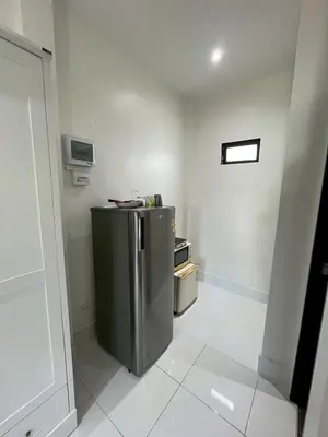 a small kitchen with a stainless steel refrigerator at J&B House in Nai Yang Beach