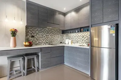 a kitchen with gray cabinets and a stainless steel refrigerator at Great 1BDR Kamala 500m to beach in Kamala Beach