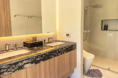 a bathroom with two sinks and a mirror and a toilet at Mouana Breeze Maikhao 3-bedroom Pool Villa 9917 in Mai Khao Beach