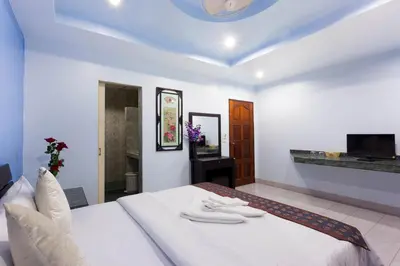 a bedroom with a bed with two towels on it at Da Mario Hotel & Restaurant in Karon Beach