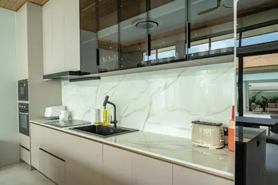 a kitchen with white marble counters and a sink at Mouana Breeze Mai Khao 4-bedroom Pool Villa 9921 in Mai Khao Beach