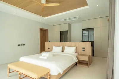 a bedroom with a large bed and a ceiling at Mouana Breeze Mai Khao 4-bedroom Pool Villa 9921 in Mai Khao Beach