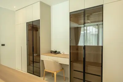a room with a desk and a chair next to a glass wall at Mouana Breeze Mai Khao 4-bedroom Pool Villa 9921 in Mai Khao Beach