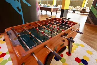 a wooden foosball table sitting on a rug at Lux 2Bdr Cassia Laguna With Own Large Terrace in Laguna Phuket