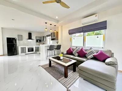 a living room with a couch and a table at The Green View Pool Villa in Kamala Beach