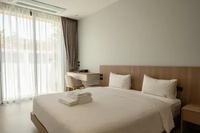 a bedroom with a bed with a desk and a window at Mouana Breeze Mai Khao 4-bedroom Pool Villa 9920 in Mai Khao Beach