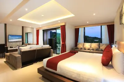 a large bedroom with a large bed and a couch at Paripas Patong Resort in Patong Beach
