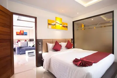 a bedroom with a large bed and a couch at Paripas Patong Resort in Patong Beach