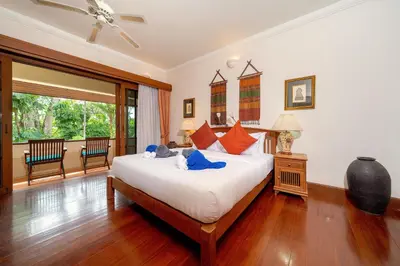 a bedroom with a large bed and a large window at Laguna Lakeshore Villas Residence - Spacious Townhouse with Tropical Pool Access in Bang Tao Beach