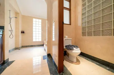 a bathroom with a toilet in a room with windows at Laguna Lakeshore Villas Residence - Spacious Townhouse with Tropical Pool Access in Bang Tao Beach