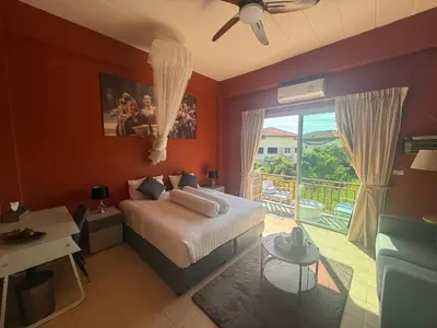 a bedroom with a bed and a view of a balcony at Alura Guesthouse in Kata Beach