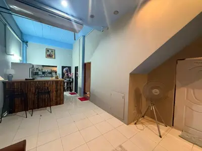 a living room with a staircase and a kitchen at Alura Guesthouse in Kata Beach