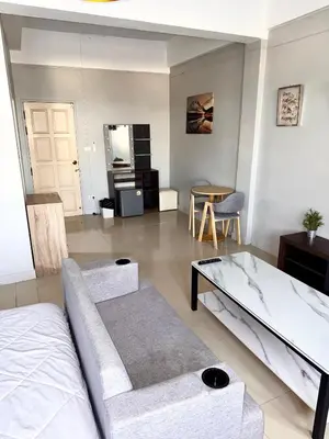 a living room with a bed and a table at Green Terrace Residence Phuket in Kathu
