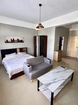a bedroom with a bed and a couch and a table at Green Terrace Residence Phuket in Kathu