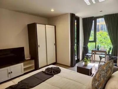 a bedroom with a bed and a television and a living room at The Base Central Phuket-B42WL in Ban Rangeng