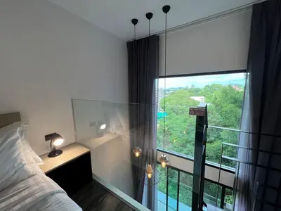 a bedroom with a bed and a large window at Modern Naiharn Beach Duplex Apartment in Rawai Beach