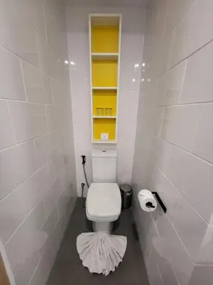 a bathroom with a toilet with a window and a rug at Modern Naiharn Beach Duplex Apartment in Rawai Beach
