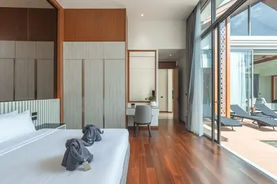 a bedroom with a white bed and a living room at V186 Quiet Glamour Oasis 4BR Poolside Sanctuary in Bang Tao Beach