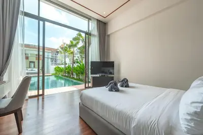 a bedroom with a bed and a television and a pool at V186 Quiet Glamour Oasis 4BR Poolside Sanctuary in Bang Tao Beach