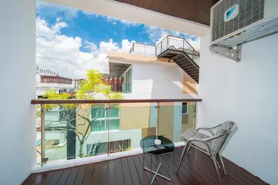 a balcony with a chair and a large window at Patong private spacious apart-ment 2 minutes walk to the beach bathtub sea view swimming pool in Patong Beach