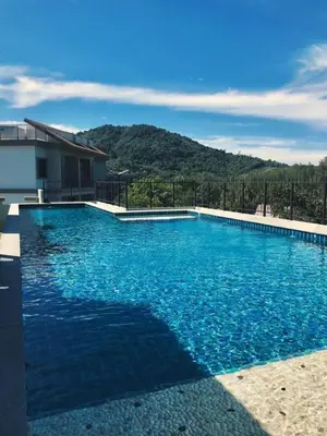 a large blue swimming pool with a mountain in the background at B8 Ватсап669З5В2I976 in Nai Yang Beach